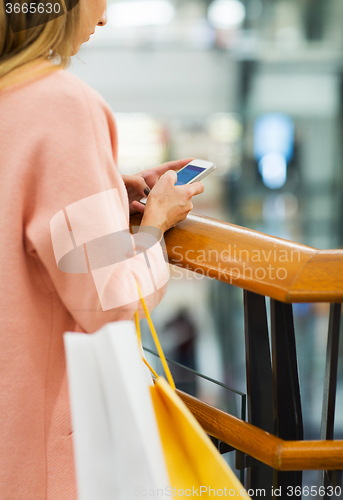 Image of close up of woman with smartphone and shopping bag
