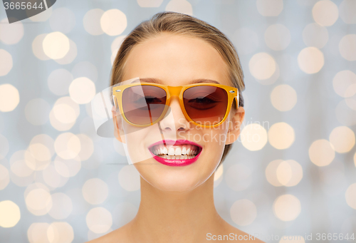 Image of happy young woman in sunglasses with pink lipstick