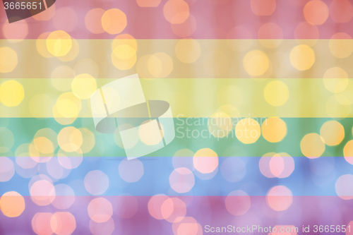 Image of blurred golden lights over rainbow flag background