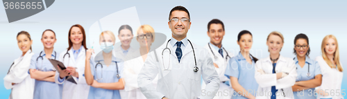 Image of group of smiling doctors with clipboard over gray