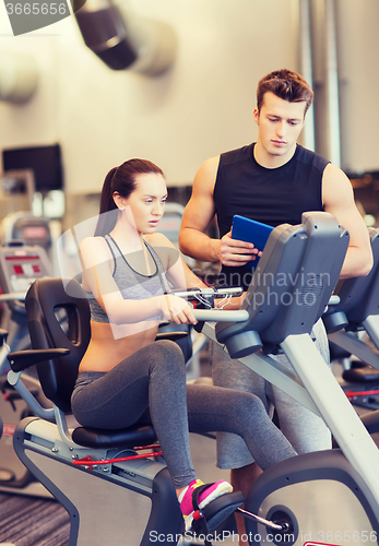 Image of woman with trainer on exercise bike in gym