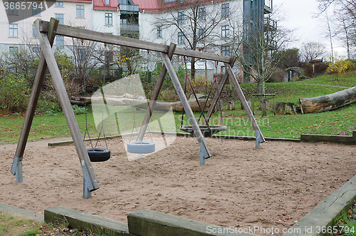 Image of the playground with three swings hanging