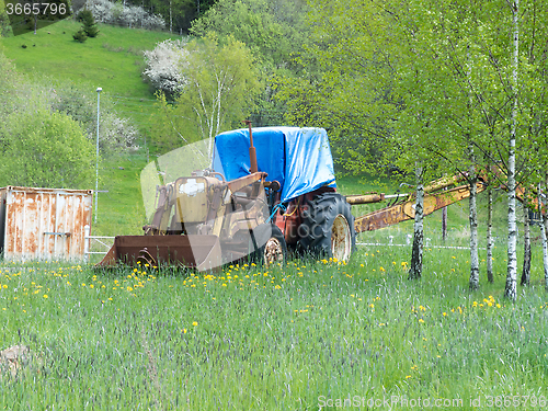 Image of one yellow old and rusty tractor 