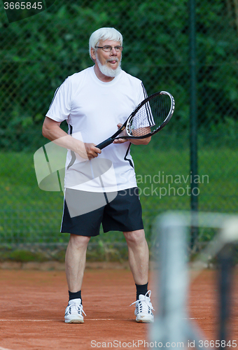 Image of Senior man playing tennis