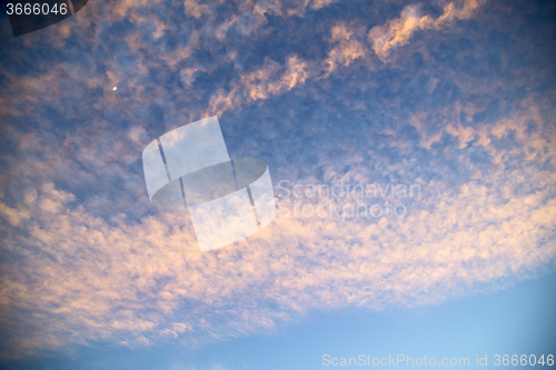 Image of sunrise in the colored sky white soft clouds moon