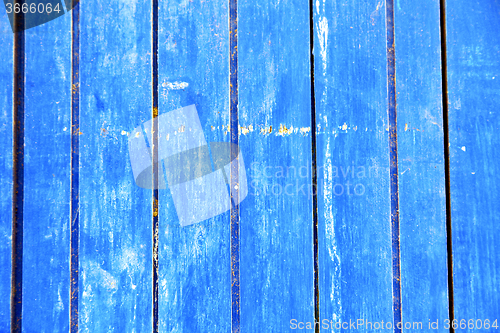 Image of stripped  in the blue door and rusty nail