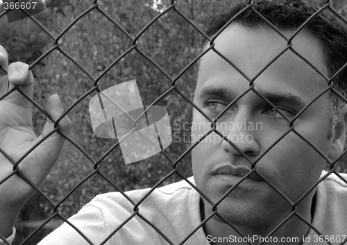 Image of Man behind a fence