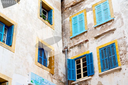 Image of blue window in  old    brown wall  construction