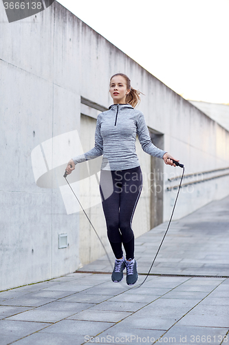 Image of woman exercising with jump-rope outdoors