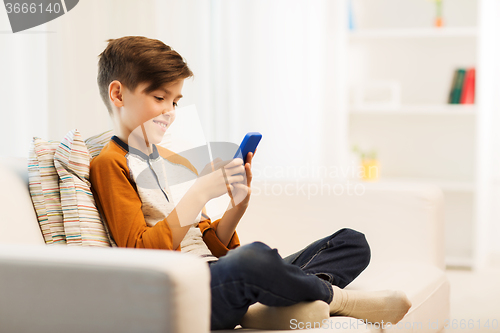 Image of boy with smartphone texting or playing at home