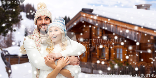 Image of smiling couple in winter clothes hugging outdoors