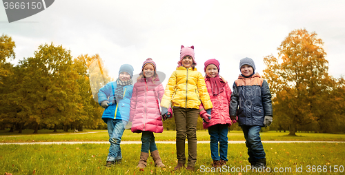Image of happy children holding hands in autumn park