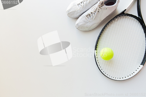 Image of close up of tennis racket with ball and sneakers