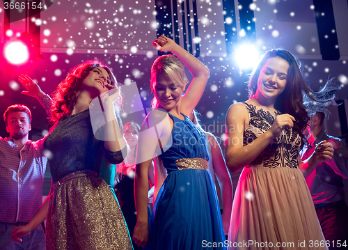 Image of smiling friends dancing in club
