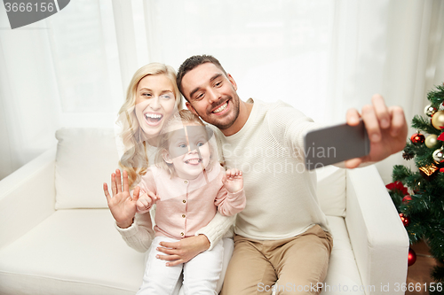 Image of family taking selfie with smartphone at christmas