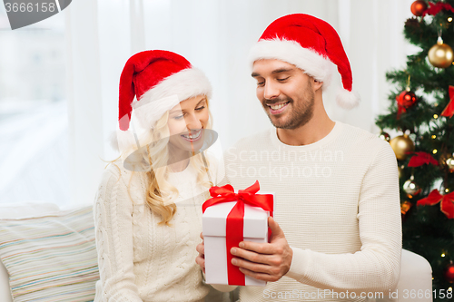 Image of happy couple at home with christmas gift box