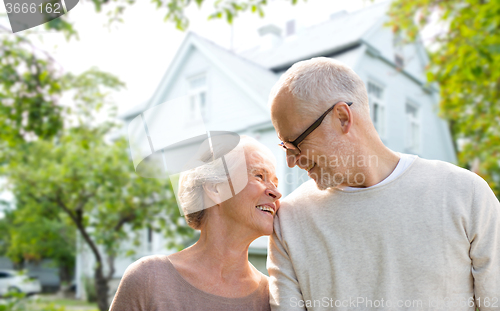 Image of senior couple hugging over living house background