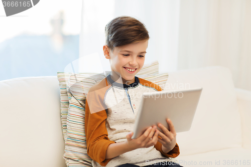 Image of smiling boy with tablet computer at home