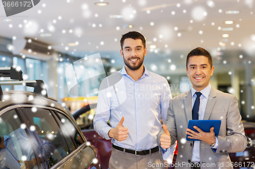 Image of happy man showing thumbs up in auto show or salon