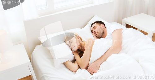 Image of happy couple sleeping in bed at home