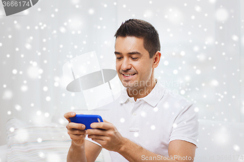 Image of happy man with smartphone at home