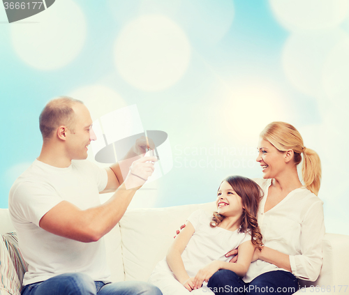 Image of happy family with camera at home
