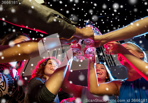 Image of smiling friends with glasses of champagne in club