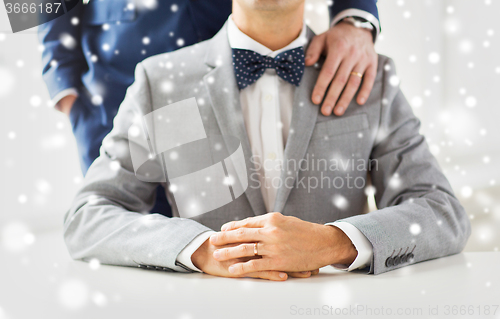 Image of close up of male gay couple with wedding rings on