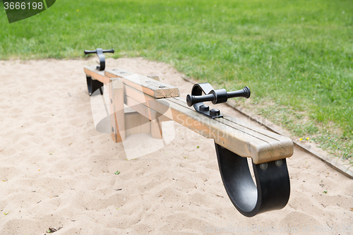 Image of close up of swing or teeterboard on playground