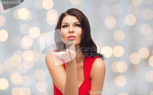 Image of beautiful sexy woman sending blow kiss over lights