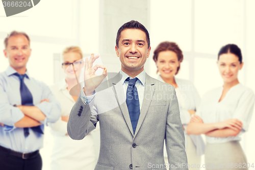 Image of happy businessman in suit showing ok hand sign