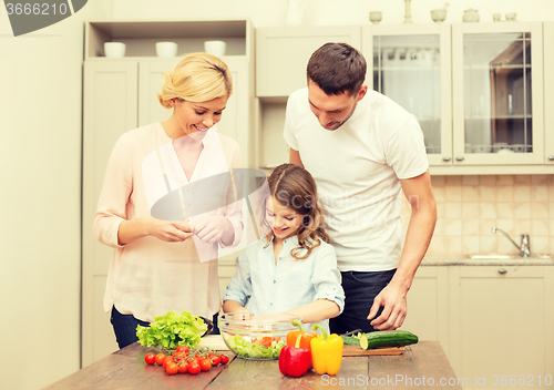 Image of happy family making dinner in kitchen