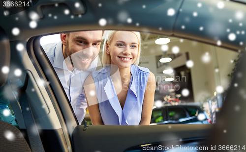 Image of happy couple buying car in auto show or salon