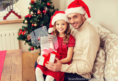 Image of smiling father and daughter holding gift box