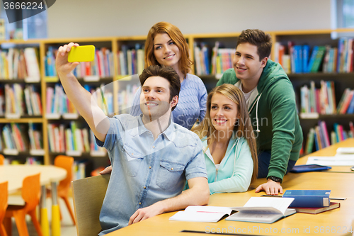 Image of students with smartphone taking selfie in library