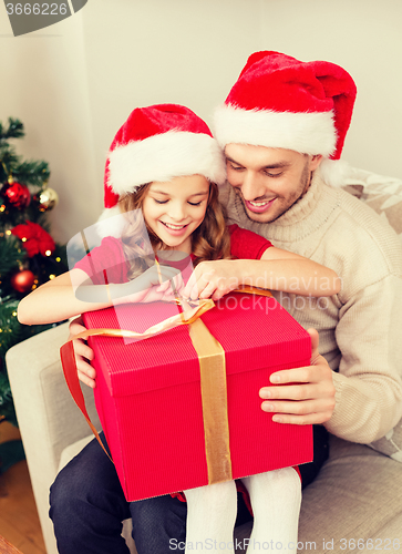 Image of smiling father and daughter opening gift box