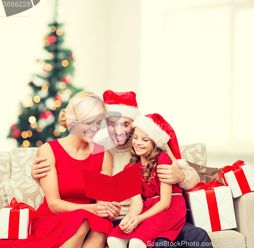 Image of smiling family reading postcard