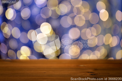 Image of empty wooden table with christmas golden lights