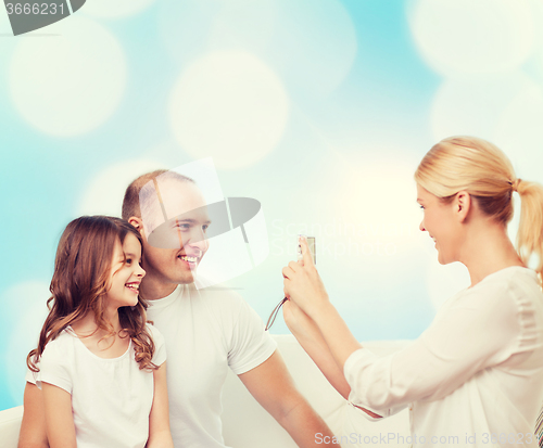 Image of happy family with camera at home