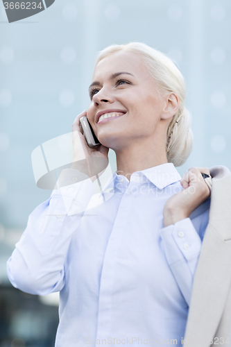 Image of smiling businesswoman with smartphone outdoors