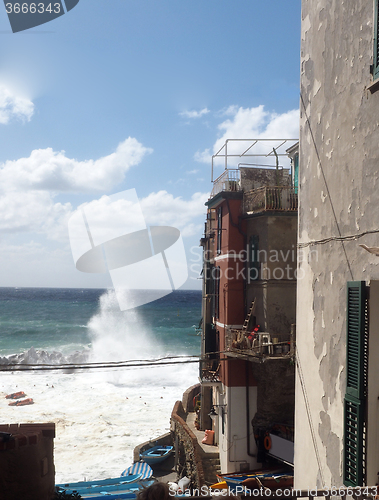 Image of Riomaggiore Cinque Terre Italy waves breaking against historic h