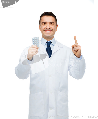 Image of smiling male doctor in white coat with tablets