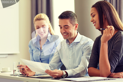 Image of business people with papers meeting in office