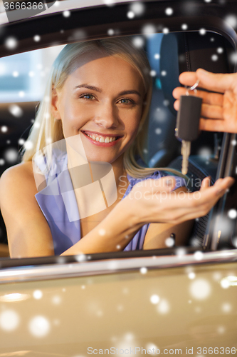 Image of happy woman getting car key in auto show or salon