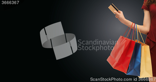 Image of close up of woman with shopping bags and bank card