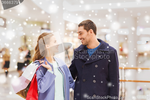 Image of happy young couple with shopping bags in mall