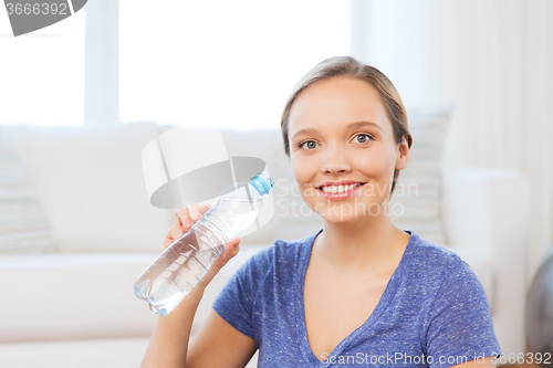 Image of happy woman with water bottle at home