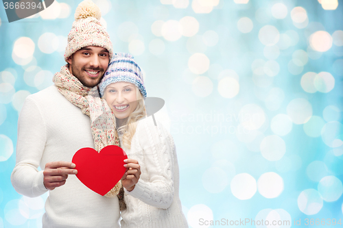 Image of smiling couple in winter clothes with red hearts