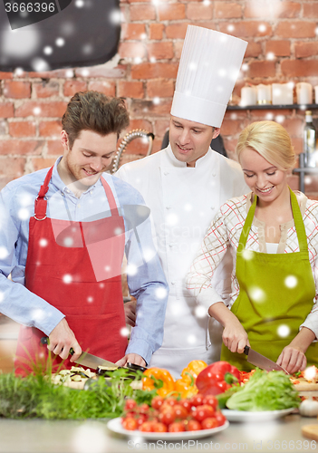 Image of happy couple and male chef cook cooking in kitchen