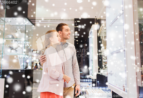 Image of couple looking to shopping window at jewelry store